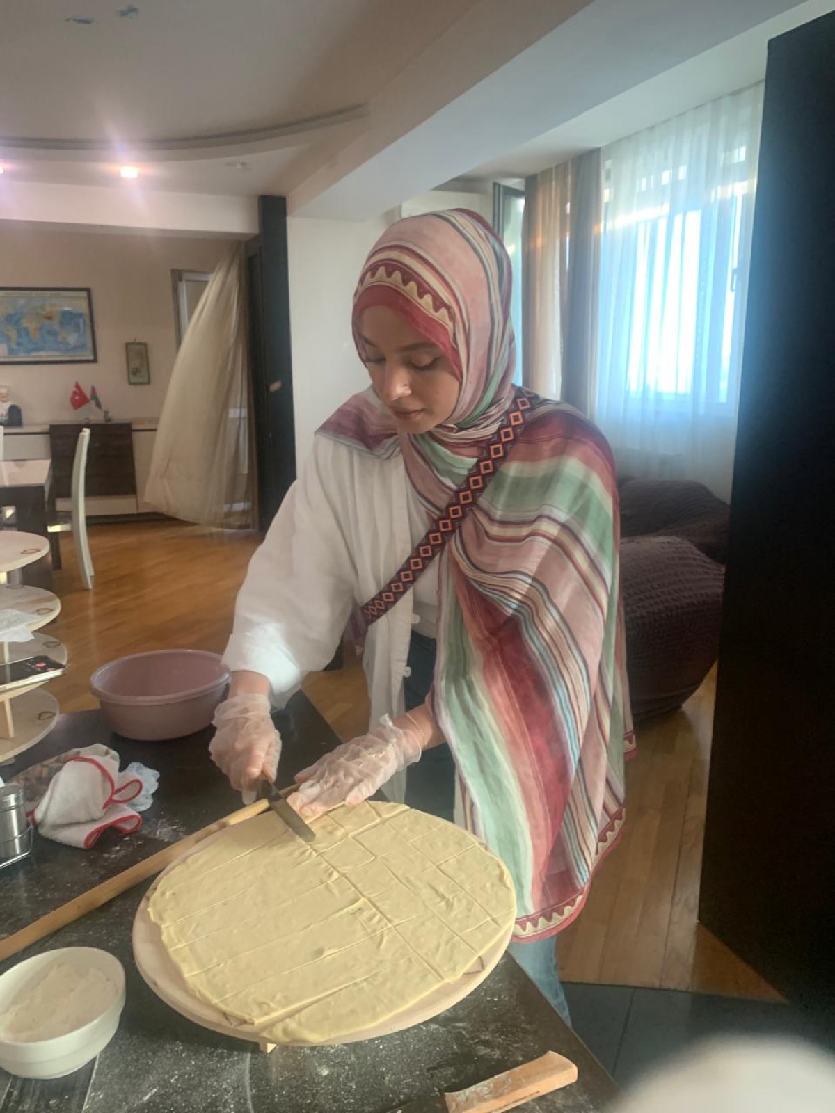 Guest cutting dough during a traditional Azerbaijani cooking workshop